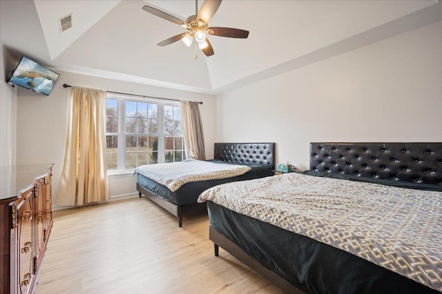 bedroom with ceiling fan, light wood-type flooring, and vaulted ceiling