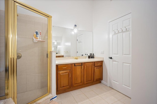 bathroom with a shower with door, vanity, and tile patterned flooring