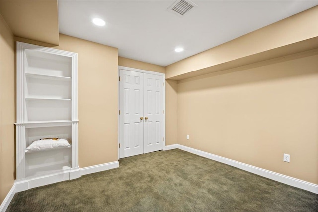 unfurnished bedroom featuring dark carpet and a closet