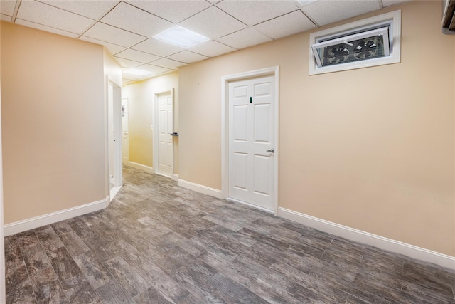 unfurnished room featuring dark hardwood / wood-style flooring and a drop ceiling