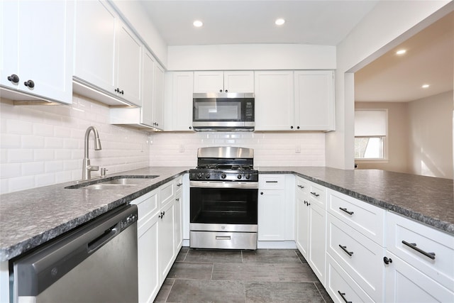 kitchen with kitchen peninsula, sink, white cabinets, and appliances with stainless steel finishes