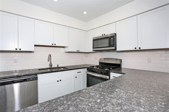 kitchen featuring decorative backsplash, sink, white cabinets, and appliances with stainless steel finishes