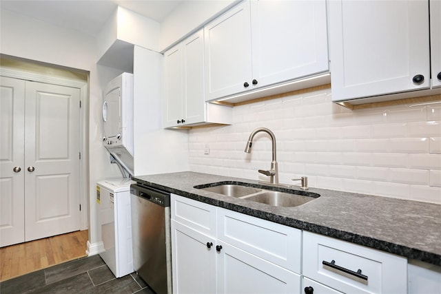 kitchen featuring dishwasher, dark wood-type flooring, sink, white cabinetry, and stacked washer / dryer