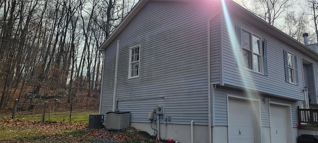 view of side of property with central AC unit and a garage