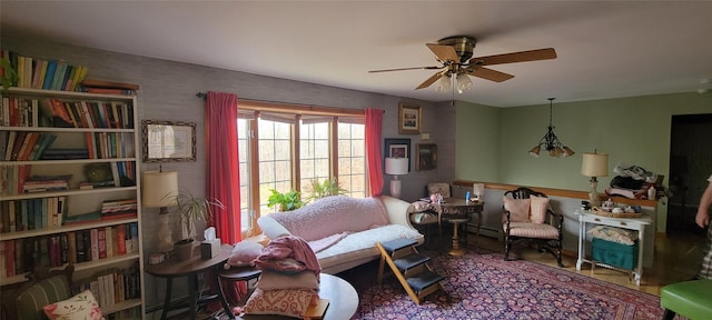 sitting room with ceiling fan with notable chandelier