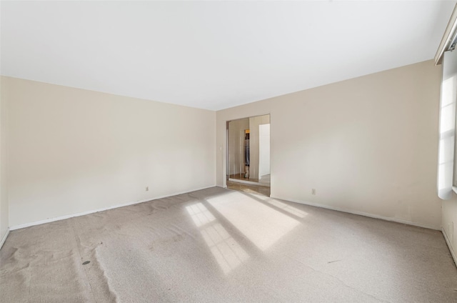 unfurnished room featuring light colored carpet