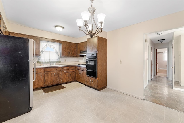 kitchen featuring sink, an inviting chandelier, hanging light fixtures, and black appliances