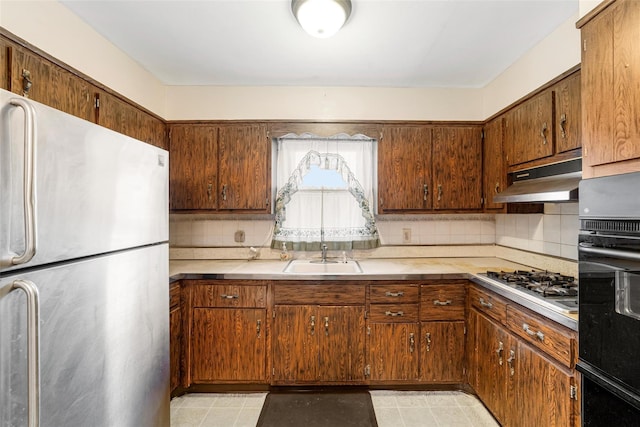 kitchen with backsplash, sink, light tile patterned floors, and stainless steel appliances