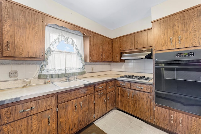 kitchen featuring white gas cooktop, sink, black double oven, and tasteful backsplash