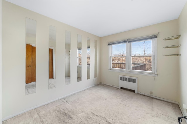 empty room featuring radiator heating unit and carpet floors