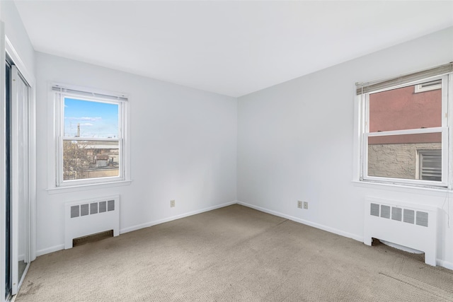 carpeted spare room featuring radiator