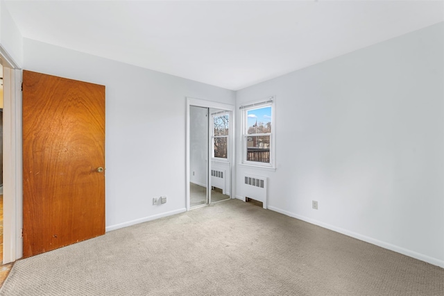 carpeted empty room with radiator heating unit