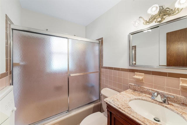 full bathroom with vanity, enclosed tub / shower combo, tile walls, and toilet