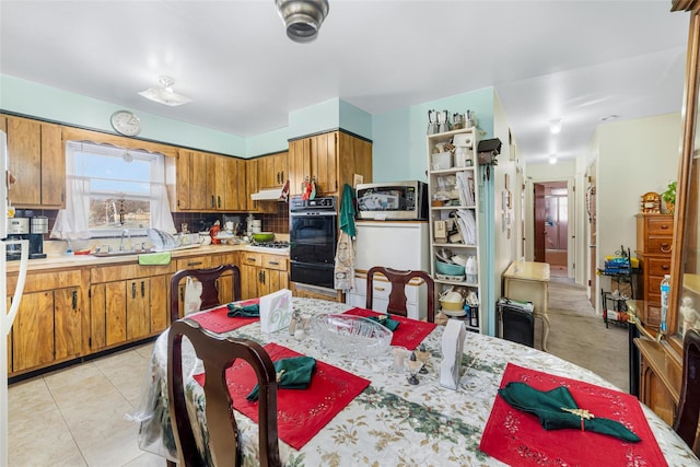 kitchen with decorative backsplash, light tile patterned floors, gas stovetop, and sink