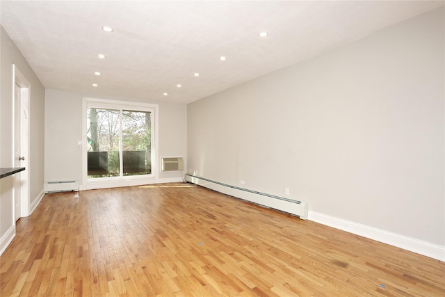 spare room with light hardwood / wood-style floors, baseboard heating, and a wall mounted AC