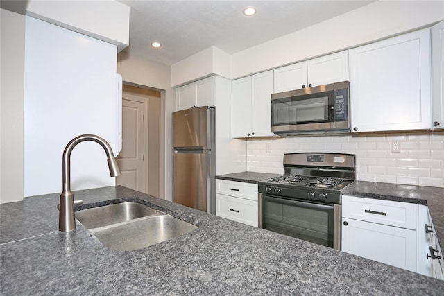 kitchen featuring appliances with stainless steel finishes, backsplash, white cabinetry, and sink