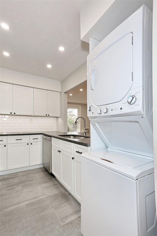 laundry area with light wood-type flooring, stacked washer / dryer, and sink