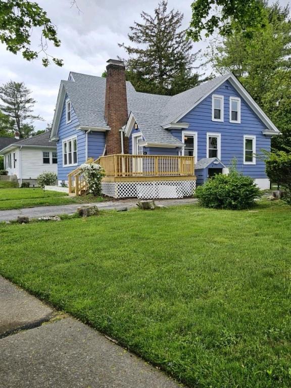 back of house featuring a yard and a wooden deck