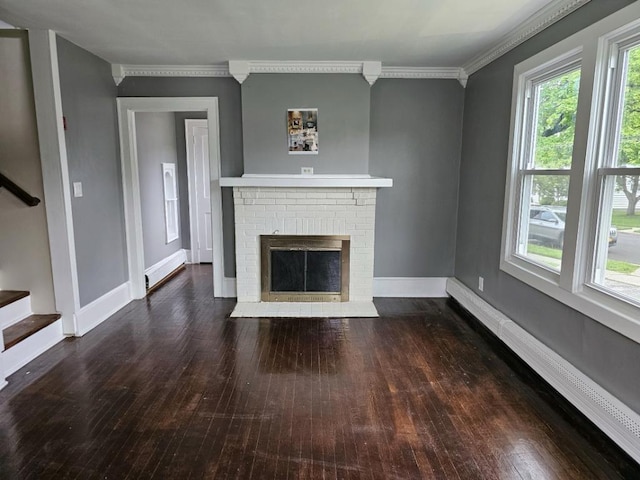 unfurnished living room with crown molding, dark hardwood / wood-style flooring, and a brick fireplace