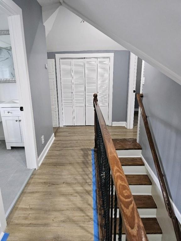 stairs featuring hardwood / wood-style flooring and lofted ceiling