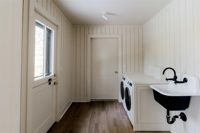 laundry room featuring hardwood / wood-style floors, washer and clothes dryer, wooden walls, and a wealth of natural light