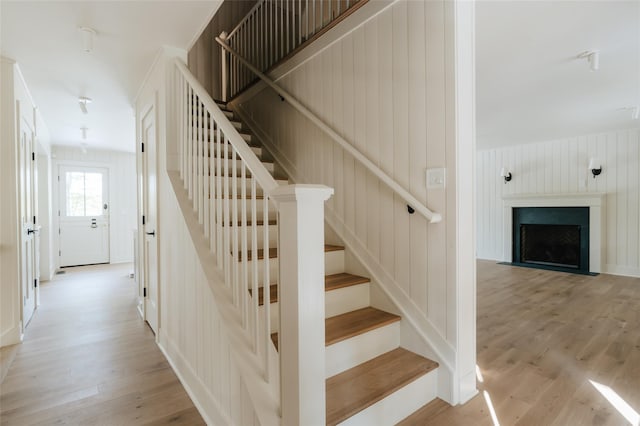 stairs featuring wood walls and wood-type flooring