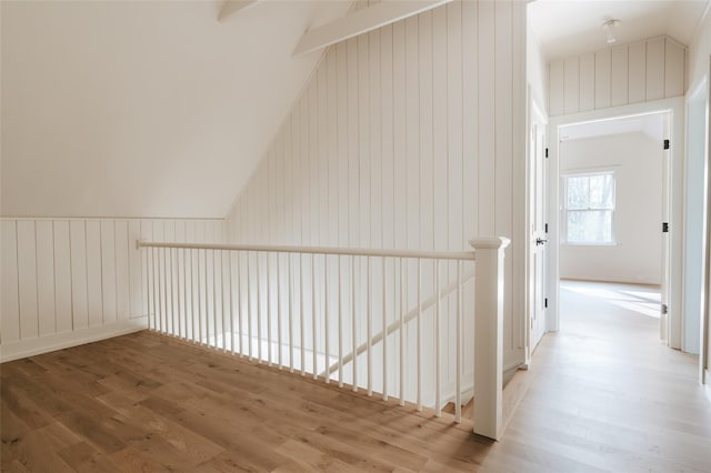 additional living space featuring hardwood / wood-style floors, wood walls, and vaulted ceiling