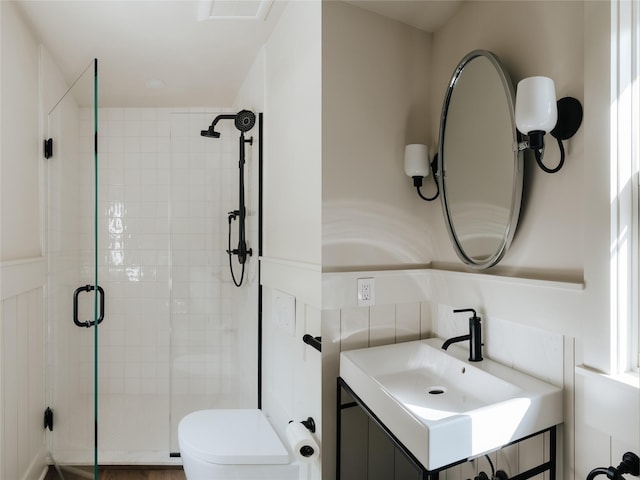 bathroom featuring vanity, toilet, and a shower with shower door