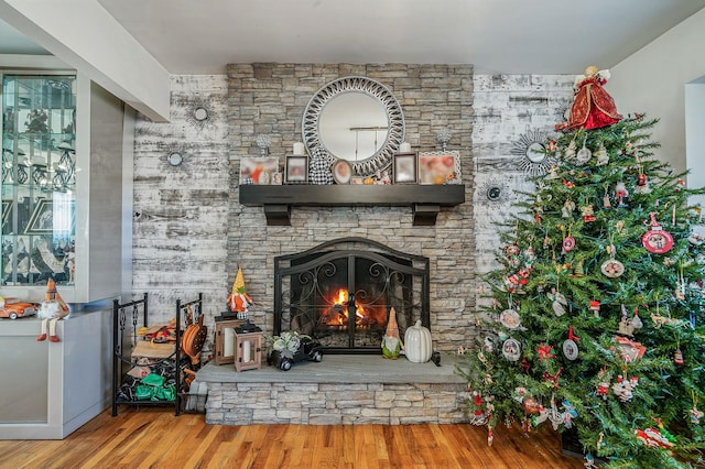 interior details featuring wood-type flooring and a stone fireplace