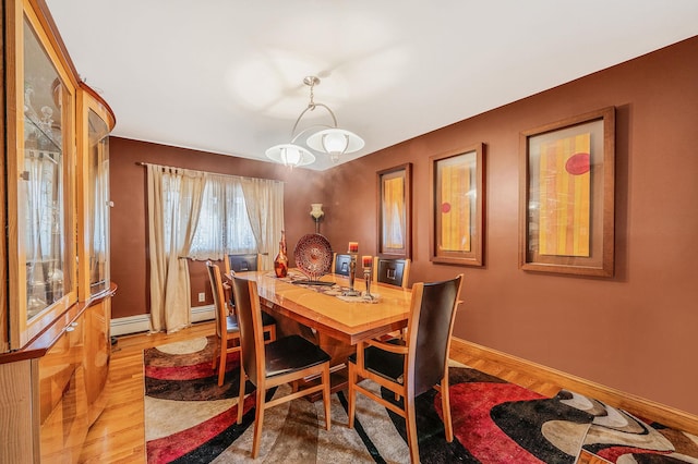 dining space with baseboard heating and light hardwood / wood-style flooring