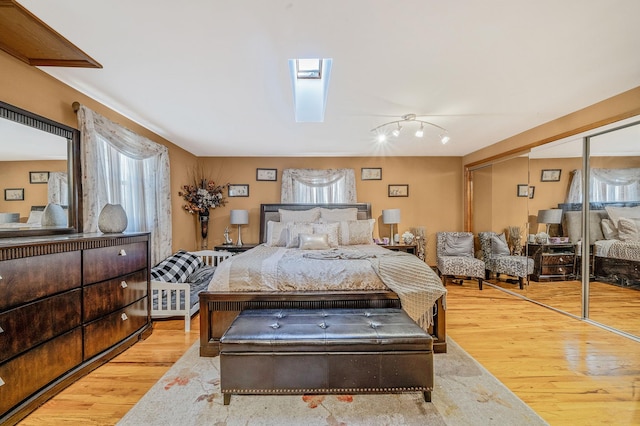 bedroom featuring a skylight, light hardwood / wood-style floors, and a closet