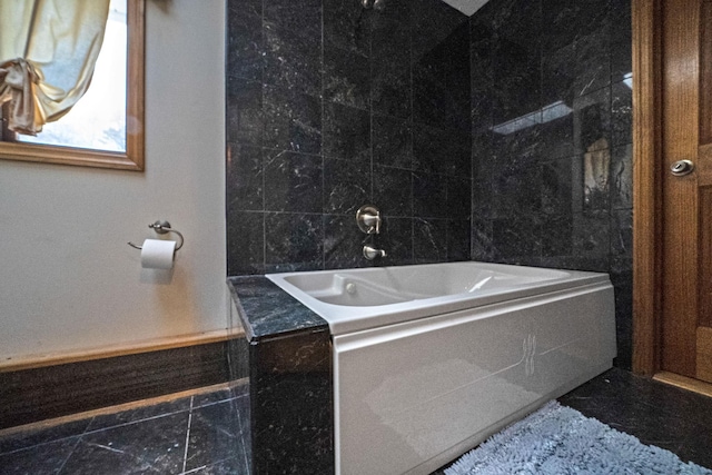 bathroom with a bathtub and tile walls