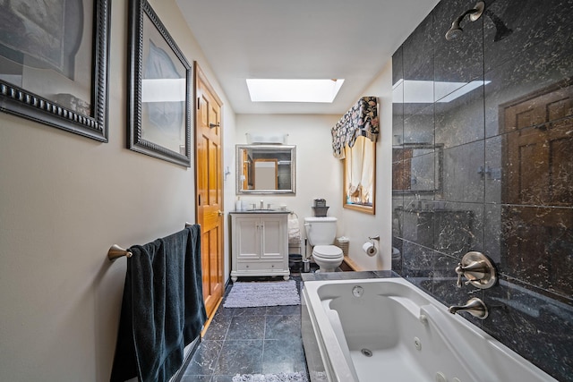 bathroom featuring vanity, tile patterned floors, a skylight, toilet, and a tub to relax in