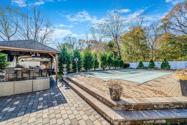 view of swimming pool with a gazebo, an outdoor kitchen, a patio, and an outdoor hangout area