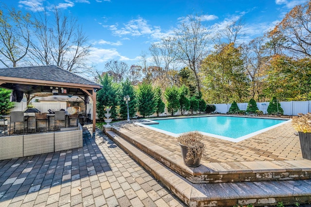 view of swimming pool with a gazebo, a bar, area for grilling, and a patio area