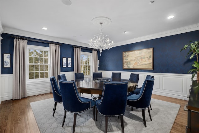 dining space featuring hardwood / wood-style floors, a notable chandelier, and ornamental molding