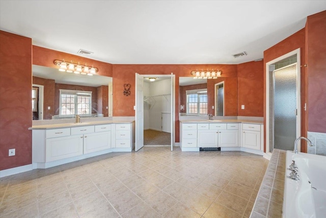 bathroom with vanity and tiled tub