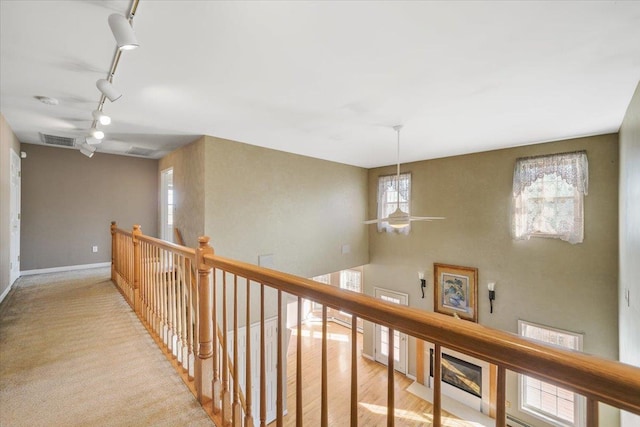 corridor with track lighting and light hardwood / wood-style flooring