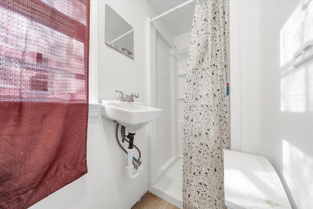 bathroom with a shower and wood-type flooring