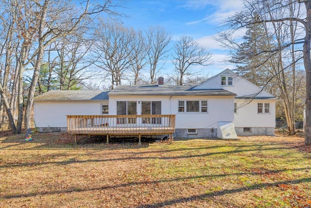 rear view of house with a lawn and a wooden deck