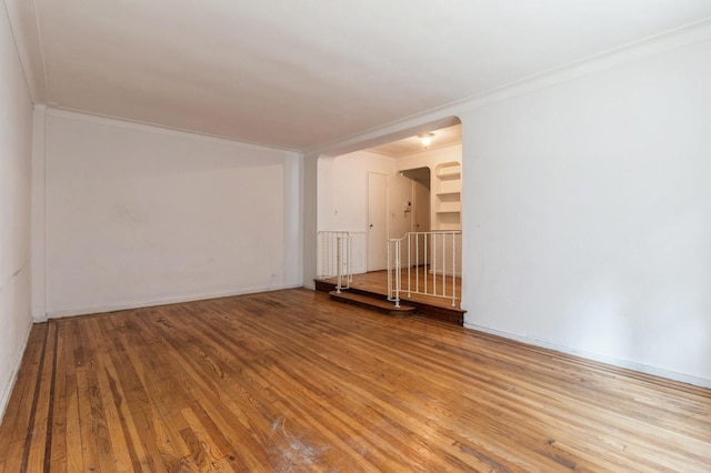 empty room featuring crown molding and hardwood / wood-style floors