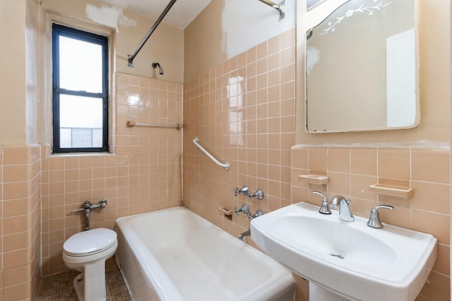 full bathroom featuring tiled shower / bath, toilet, tile walls, and sink