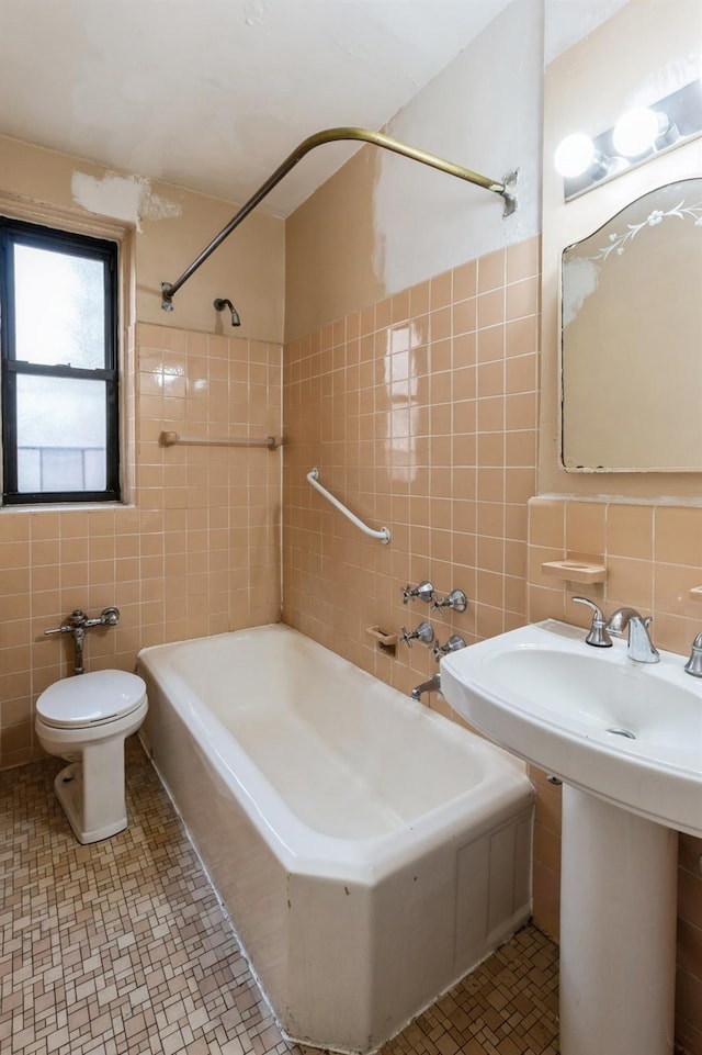 bathroom featuring sink, tile walls, and toilet