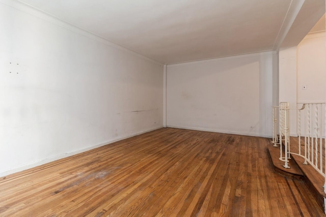 empty room with hardwood / wood-style flooring and ornamental molding