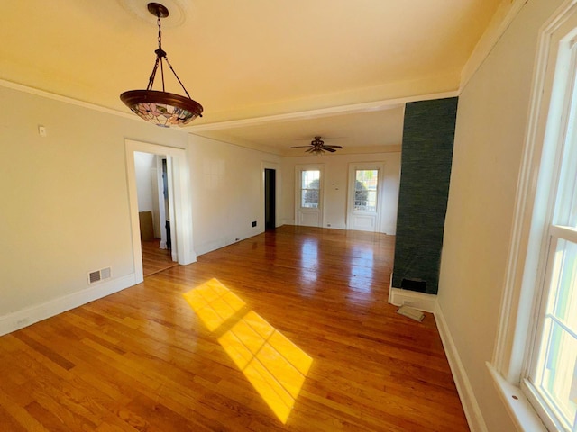 interior space with ceiling fan, ornamental molding, and hardwood / wood-style flooring