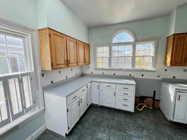 kitchen featuring backsplash, white cabinetry, and dark tile patterned floors