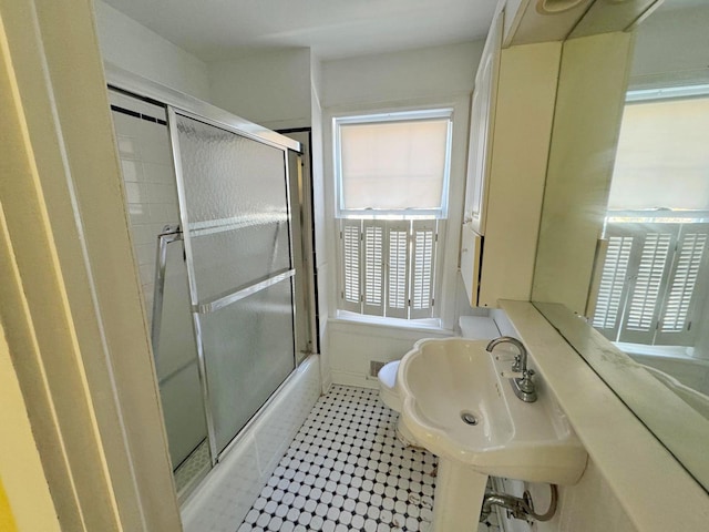 bathroom with tile patterned floors, shower / bath combination with glass door, and toilet