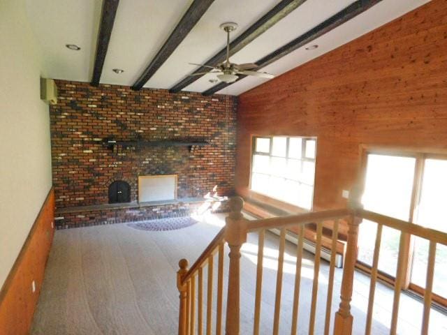 unfurnished living room featuring lofted ceiling with beams, ceiling fan, and a baseboard heating unit