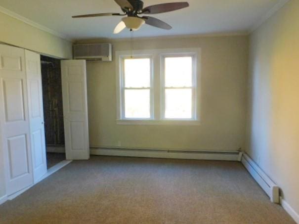 unfurnished bedroom with a wall mounted AC, ceiling fan, crown molding, and light colored carpet