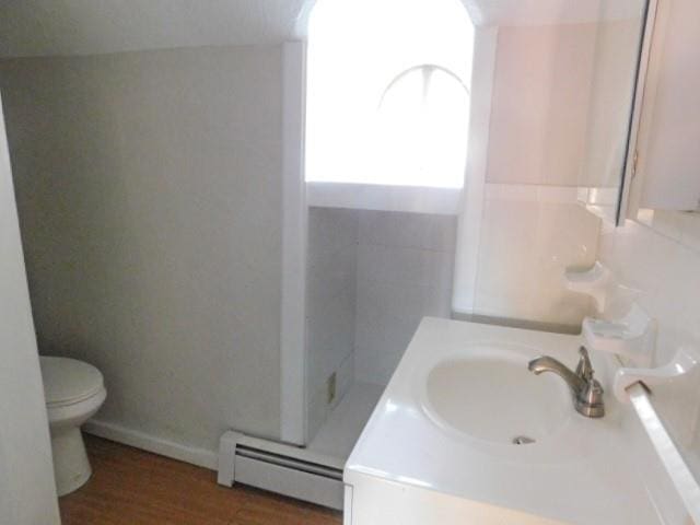 452 St Andrews Rd, Walden, NY 12586 - bathroom featuring a baseboard heating unit, toilet, vanity, and wood finished floors